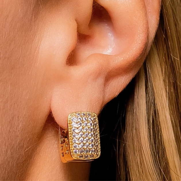modelo e Brinco retangular cravejado com microzircônias banhado a ouro