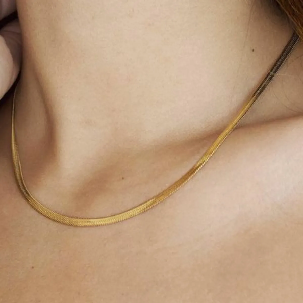 Colar Luxe 02 com acabamento liso banhado a ouro 18K no pescoço feminino