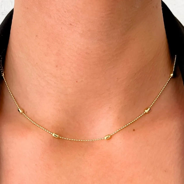 Colar Stream com bolinhas delicadas banhado a ouro 18K no pescoço feminino